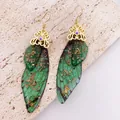 Close-up of green cicada wing earrings with gold foil accents and ornate metalwork. - Gold Foil Decoration / Dreamy Green