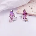 Vista macro detallada de pendientes de ala de mariposa morada con detalles de cristal - Base de Plata / Púrpura