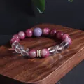 Handgefertigtes Natursteinarmband mit rosa und lila Perlen auf einem Holzblock - Rosa Turmalin Armband / Rosa Turmalin Weißer Kristall