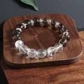 Makro-Detail von Rauchquarz- und klarem Kristallperlenarmband mit silbernen Abständen - Rauchquarz Bergkristall Gemischtes Armband