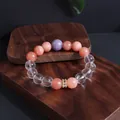 Nahaufnahme eines bunten Steinperlenarmbands auf professionellen Schmuckblöcken aus Holz - Sonnenstein Weißer Kristall