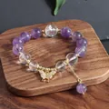 Detailansicht eines Amethyst-Perlenarmbands mit einem funkelnden goldenen Schmetterling - Lila (Amethyst Schmetterling Quaste)