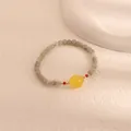 Detailed macro view of an elegant moonstone and citrine bead bracelet with gold accents - Citrine Style