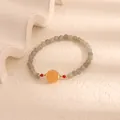 Detailed macro view of moonstone bracelet with central orange pumpkin chalcedony bead - Yellow Pumpkin Bead Style