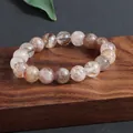 Primer plano detallado de una pulsera de cuentas de cristal de cuarzo rutilado super siete. - Pulsera Super Siete Oro Negro / 10mm