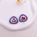 Primer plano de pendientes morados irregulares con flores secas reales y hojas verdes naturales - Púrpura
