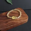 Macro view of natural citrine bracelet with carved pixiu charm on wooden display - Pixiu (5633710176780) / Single Loop