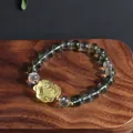 Detailed macro view of green phantom crystal bracelet with yellow lion dance charm - Nine-Tailed Fox Style / Green & Yellow