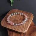 Vue détaillée d'un bracelet en quartz fraise et cristal orné d'une breloque Pixiu rose. - Style 1