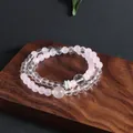 Detailed view of a double-strand rose quartz and clear quartz beaded bracelet on wood. - Rose Quartz Moonstone Double Layer Bracelet