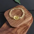 Close-up detail of natural citrine beads and a carved flower charm on a wooden stand - Nine-Tailed Fox (5633710176781) / Single Loop