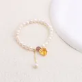 Macro view of natural freshwater pearl bracelet featuring a yellow heart gemstone pendant - Yellow Rhinestone Heart Style