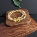 Detailed macro view of natural yellow citrine crystal bracelet with a carved fox pendant - Bear (5633710176782)