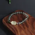 Close-up of green phantom quartz bracelet with carved yellow crystal lion charm - Pi Xiu Style 2
