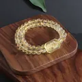 Close-up detail of natural citrine double-strand bracelet with carved fox charm - Floral Plate (5633710176783)