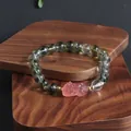 Detailed view of a Green Ghost crystal bracelet featuring a pink mythical creature charm. - Pi Xiu Style 1 (Strawberry Quartz)