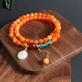 Vista detallada de la pulsera de piedra natural naranja con dije de jade blanco - Pulsera de Hebilla de Paz de Piedra del Sol Dorada