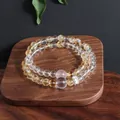 Close-up detail view of a double-layer natural crystal bead bracelet on a wooden tray - Citrine Moonstone Double Layer Bracelet