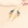 Elegant butterfly wing drop earrings with blue gradient and gold-tone hollow design - Gold Frame / Light Blue