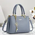 Elegant blue leather handbag with gold-tone hardware and detailed decorative charm detail - 26*11*18 / Blue