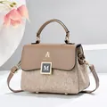 Detailweergave van de elegante bruine handtas met gouden M-gesp en stevige draaggreep. - 21*12*17 / Khaki