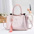 Elegant pink textured leather handbag with tassel charm, top handle, and shoulder strap - 28*12*19 / Pink Style One