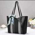 Side view of a large black tote bag featuring a striped panel and decorative silk scarf - 32x11x28cm / Black