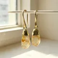Close-up of raw citrine crystal earrings with gold-plated hooks in natural sunlight - Drop Earrings / Citrine