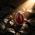Close-up of a vintage egg-shaped red agate ring with a textured bronze band detail - Adjustable Open / Red Agate