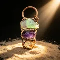 Detail of vintage copper wrapped raw amethyst and fluorite pendant under warm light - Random Shape
