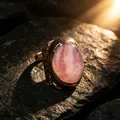 Close-up detail of a vintage bronze ring with a large oval rose quartz stone on stone - Adjustable Open / Rose Quartz