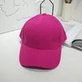Detailed view of a bright fuchsia pink plain baseball cap on a minimalist white desk setup - 55-60cm / Rose Red