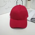 Close-up of a solid red baseball cap with cotton twill texture in lifestyle setting - 55-60cm / Red