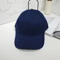 Classic navy blue cotton baseball cap with curved brim on white minimalist desk - 55-60cm / Navy Blue