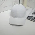 Detail view of a plain white cotton baseball cap in a minimalist setting - 55-60cm / White