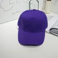Close-up of a vibrant purple solid color baseball cap with a curved brim. - 55-60cm / Purple