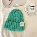 Dettaglio di berretto in maglia a trecce verde menta con toppa per il calore invernale. - 55-59cm / Blu