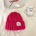 Vista dettagliata del berretto in maglia rosa acceso con etichetta FUAXING FASHION - 55-59cm / Rosso rosa