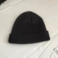 Detailed view of the texture and style of a black short knit beanie for autumn and winter - One Size / Black
