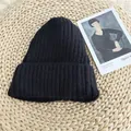 Detail view of a black ribbed knit beanie hat showing soft and cozy woolen texture - 54-58cm / Black