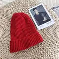 Red ribbed knitted beanie hat for winter, shown on a rustic woven background texture - 54-58cm / Red