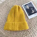Close-up of mustard yellow ribbed knitted beanie hat on woven texture background - 54-58cm / Yellow