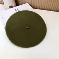 Close-up detail of an olive green wool beret hat showing soft textured fabric finish - 55-58cm (Stretchy) / Beret / Grass Green