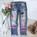 Detailansicht von Distressed-Jeans mit rosa Blumen-Patches und LOVE-Aufdruck. - Blau mit rosa Gitterdruck