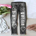 Detailansicht der grauen Jeans mit Distressed-Optik, Herzprints und Liebes-Patches. - Schwarz mit weißen Buchstabenherzen