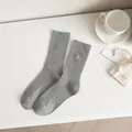 Calzini grigi a coste a metà polpaccio con un simpatico sorriso giallo ricamato. - Taglia unica / Grigio chiaro