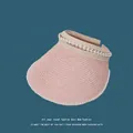 Macro detail shot of a pink woven empty top sun visor with elegant pearl trim decoration - 55-59cm / Pink