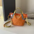 Detailed view of bright orange grid texture nylon crossbody bag with yellow straps - Orange