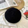Macro view of black breathable knitted beret hat showing texture on lifestyle background - 55-59cm / Black