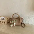 Detail view of khaki bucket bag with elegant pearl bow and tulip flower charm - With Pendant / Khaki with Pendant